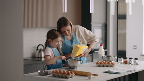 Das-Kleine-Mädchen-Und-Ihre-Mutter-Kochen-Teig-Für-Kuchen-In-Der-Küche-Zu-Hause.-Mutter-Und-Tochter-Verbringen-Zeit-Miteinander.